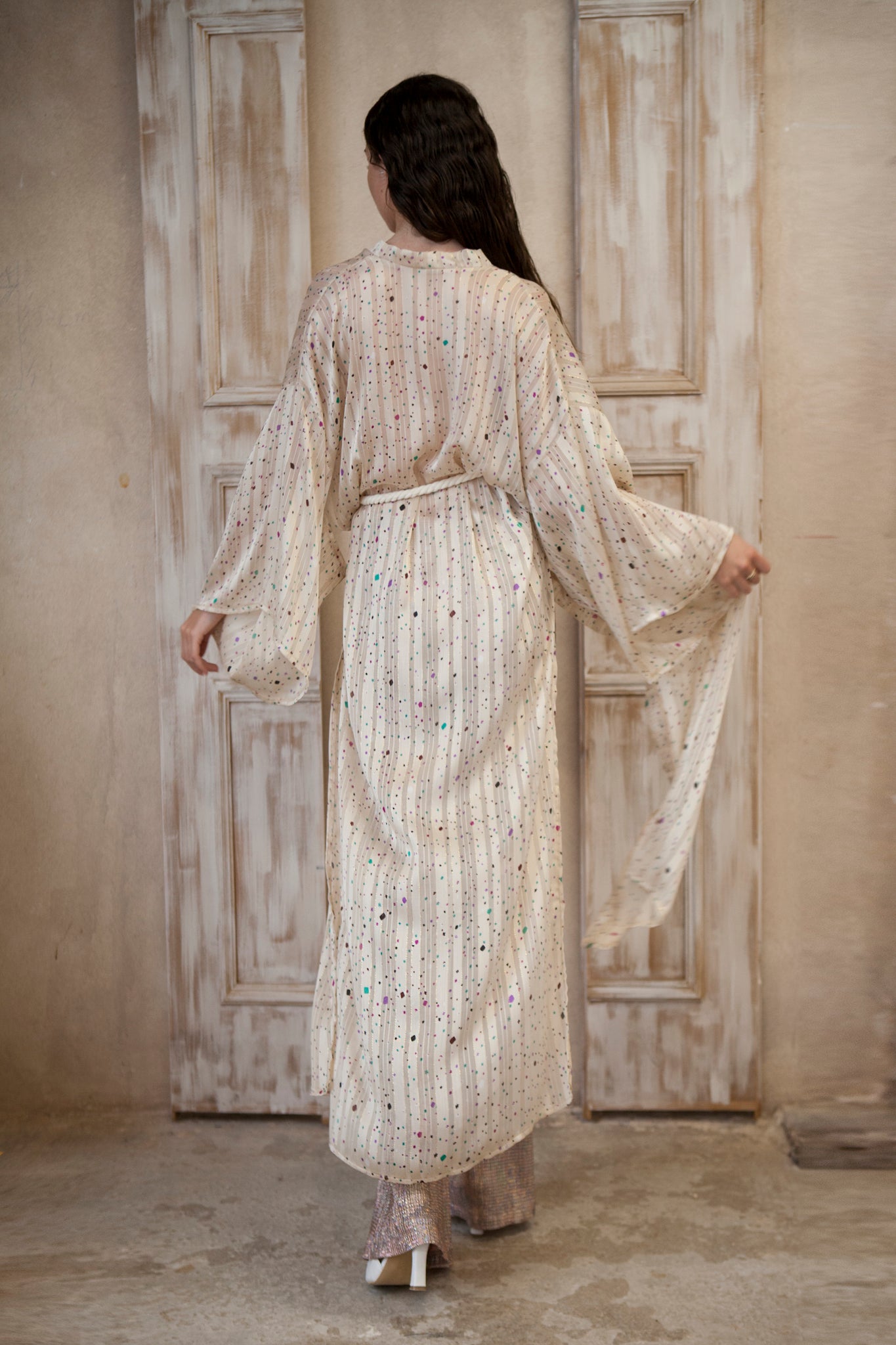 Long-sleeved kimono, featuring a cream hue adorned with playful colored spots and sparkling gold lines