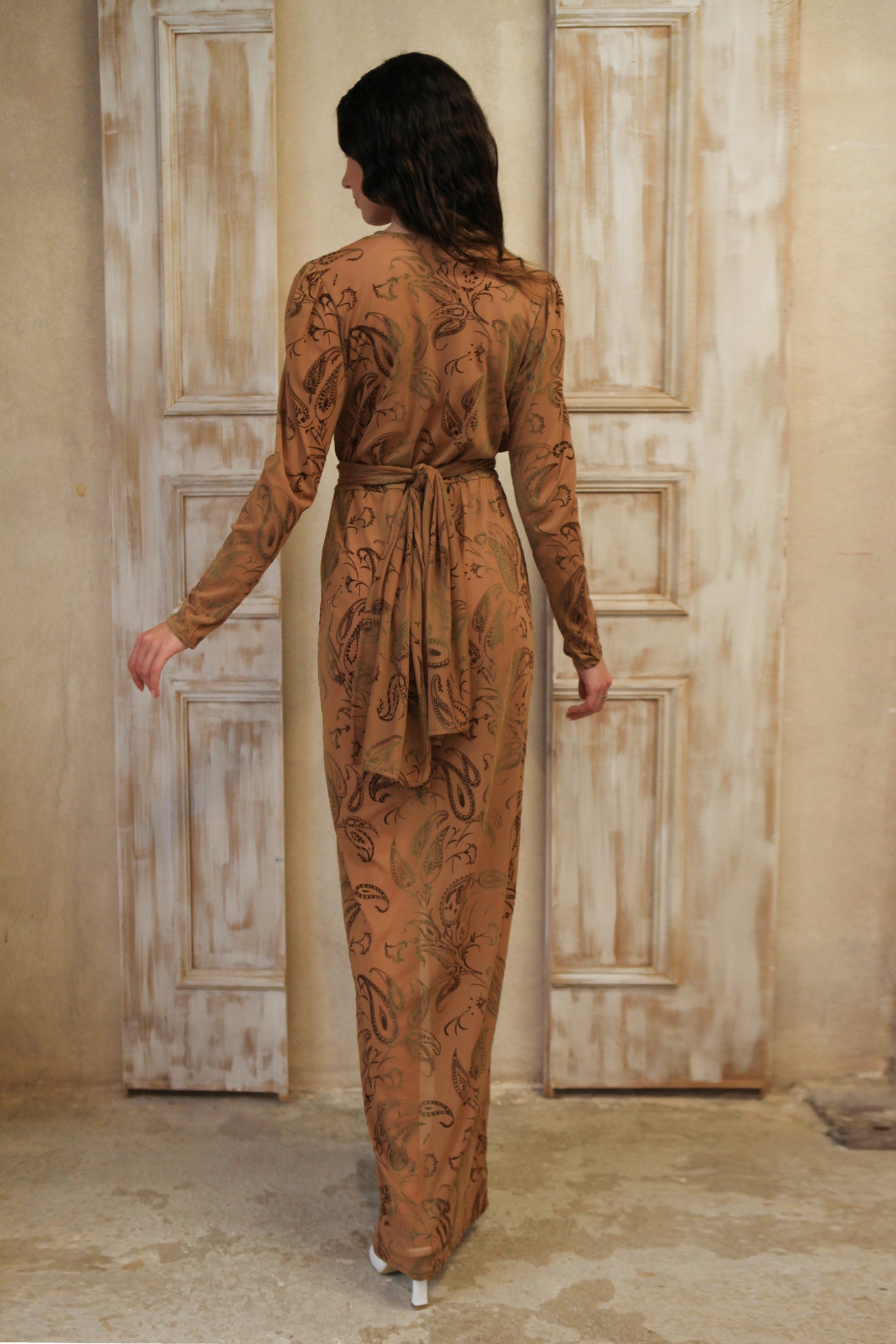 Long sleeve long wrap dress, featuring a captivating brown hue adorned with bold paisley prints.