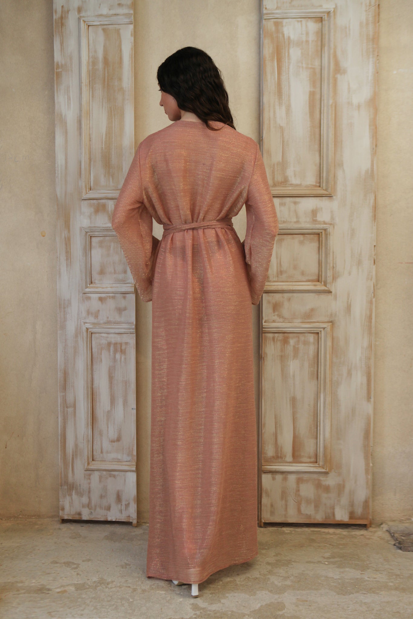 Long-sleeved, maxi-length wrap designed dress. Crafted from glinting fabric