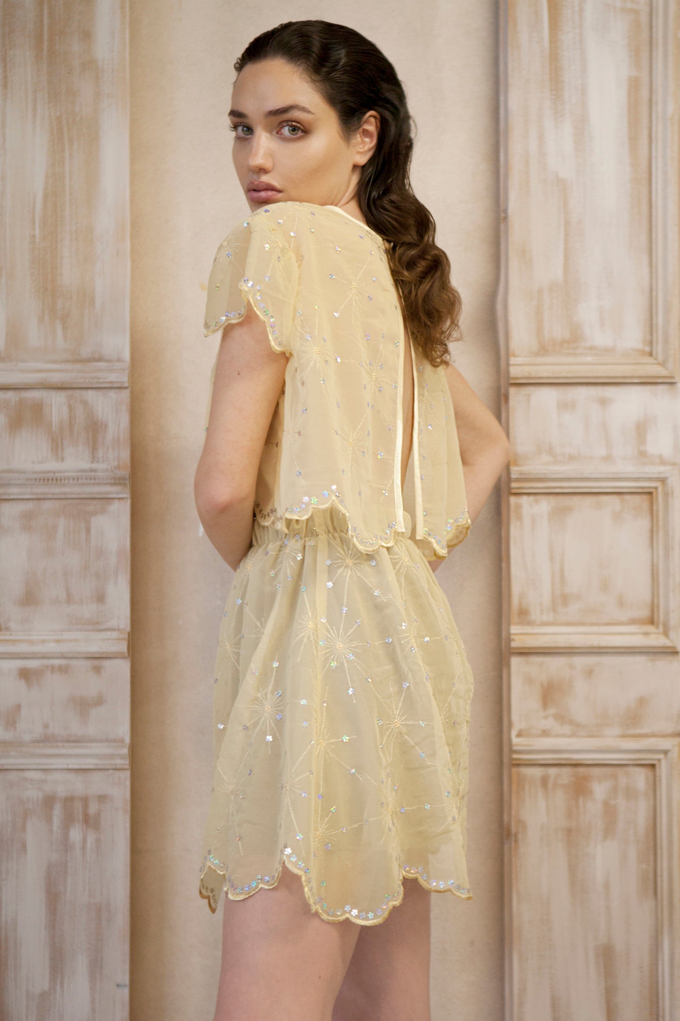 Yellow gold mini skirt adorned with delicate gold light sequins. This enchanting piece features a flowery ending